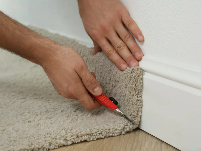 Worker,With,Cutter,Knife,Installing,New,Carpet,Indoors,,Closeup